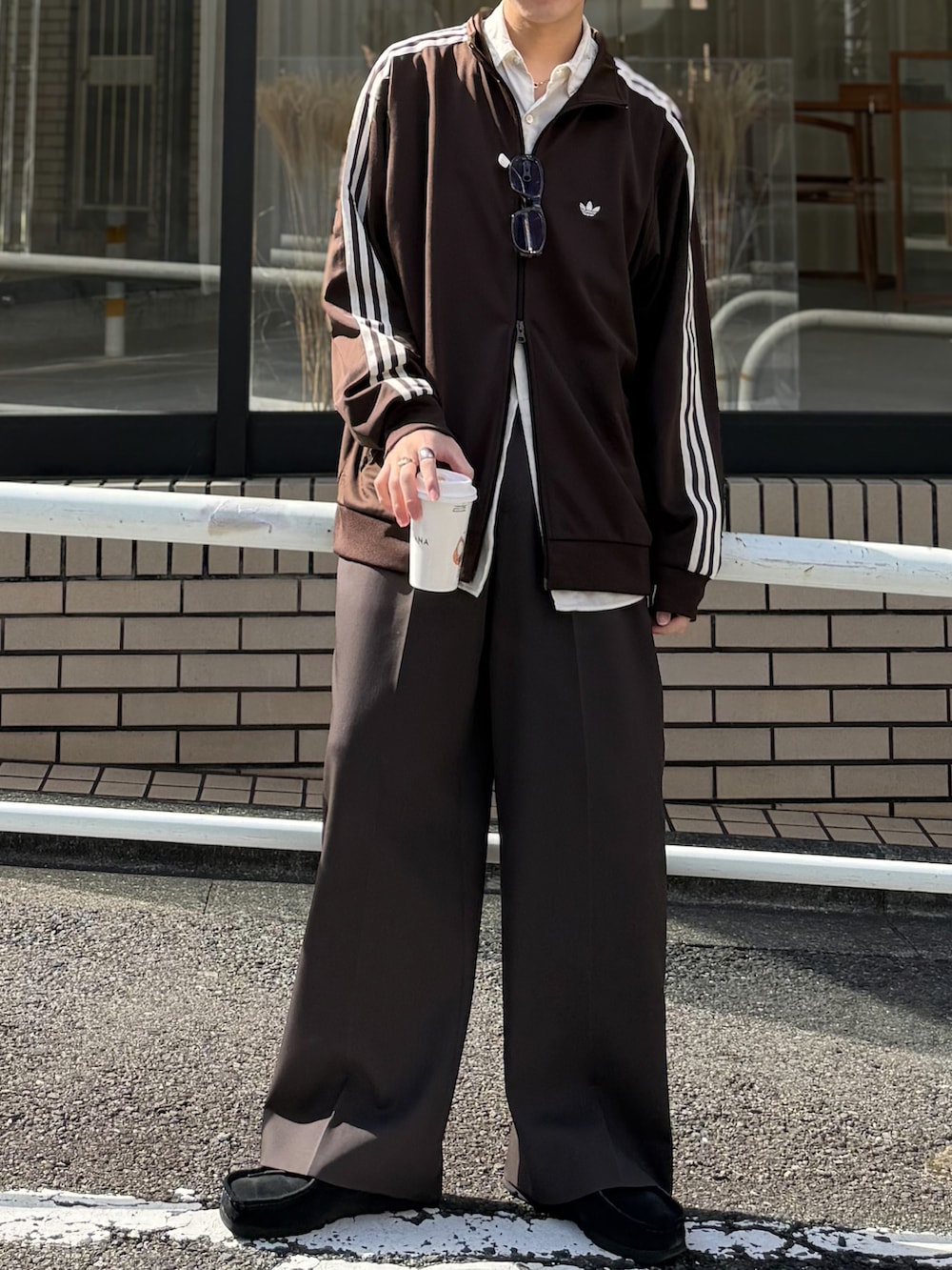 ブラウン系のジャージ、ブラック系のモカシン/デッキシューズ、ブラウン系のサングラスを着用したメンズの秋コーディネートの4枚目の写真