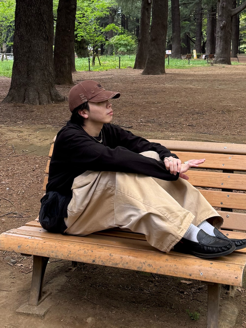 ブラック系のTシャツ/カットソー、ベージュ系のチノパンツ、ブラック系のボディバッグ/ウエストポーチを着用したメンズの春コーディネートの4枚目の写真