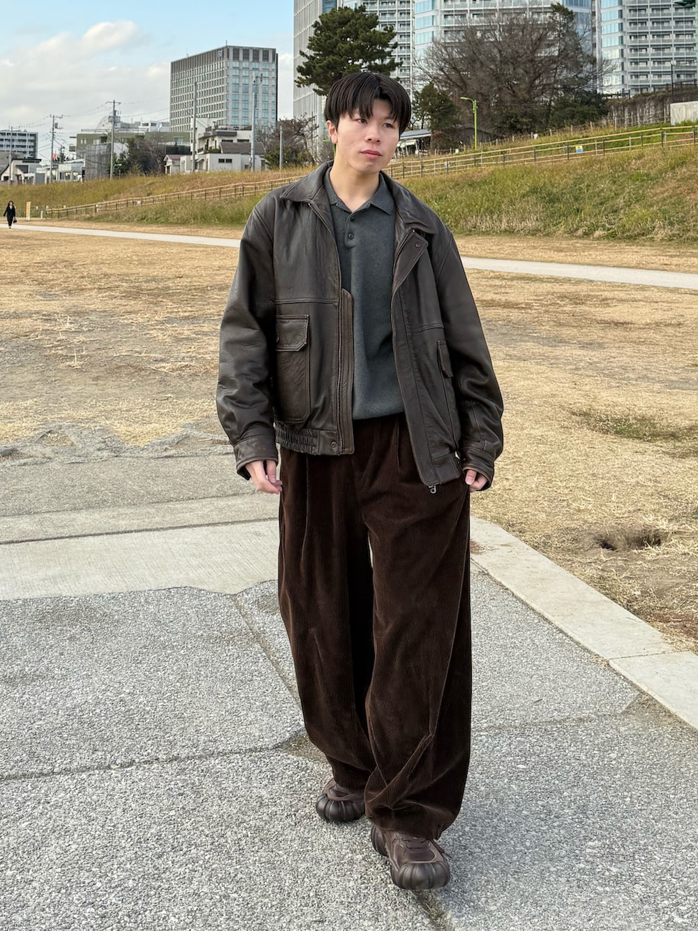 ブラウン系のブルゾン、グレー系のニット/セーター、ブラウン系のその他パンツを着用したメンズの冬コーディネートの2枚目の写真