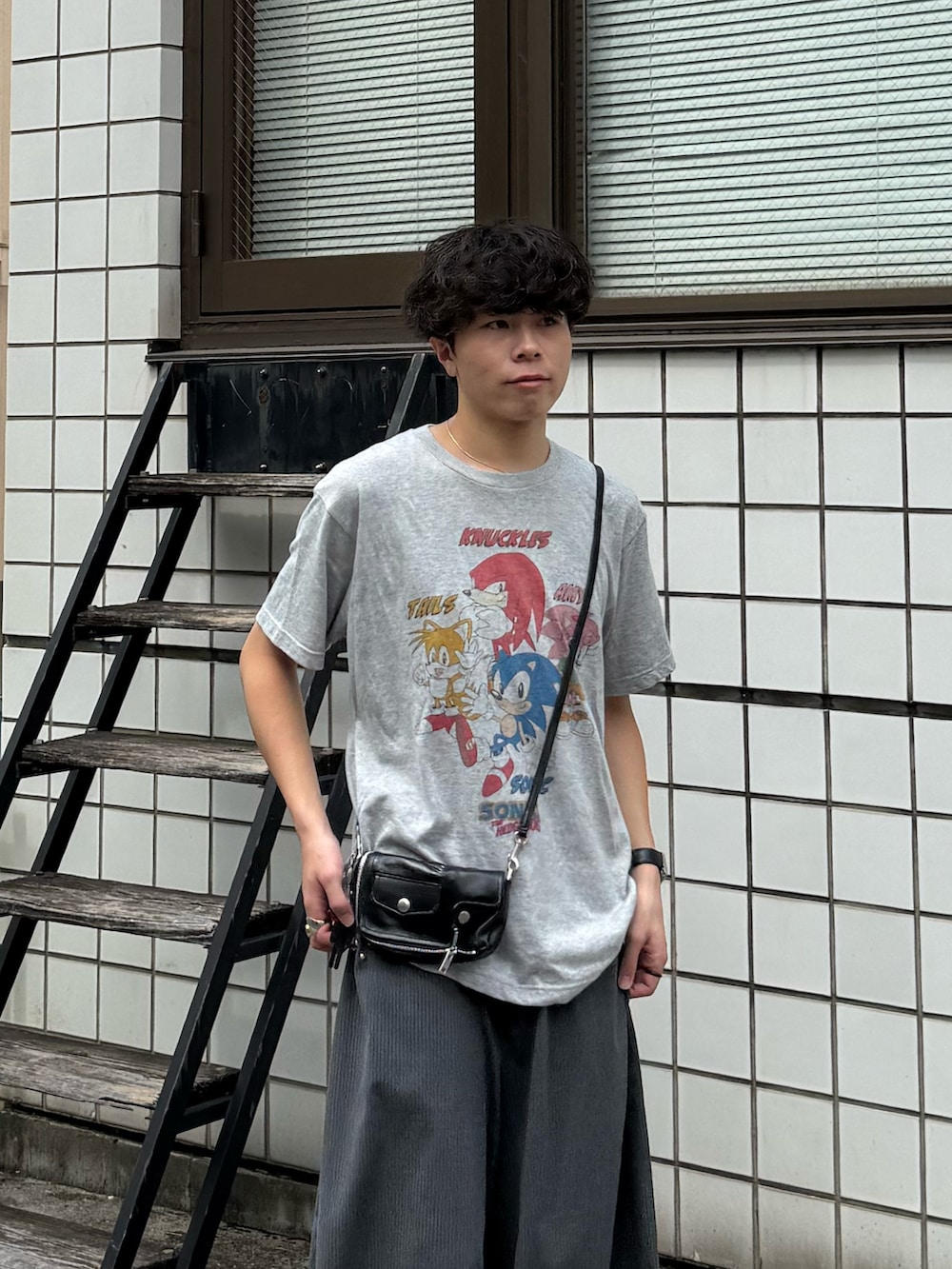 グレー系のTシャツ/カットソー、グレー系のスラックス、ブラック系のローファーを着用したメンズの夏コーディネートの2枚目の写真