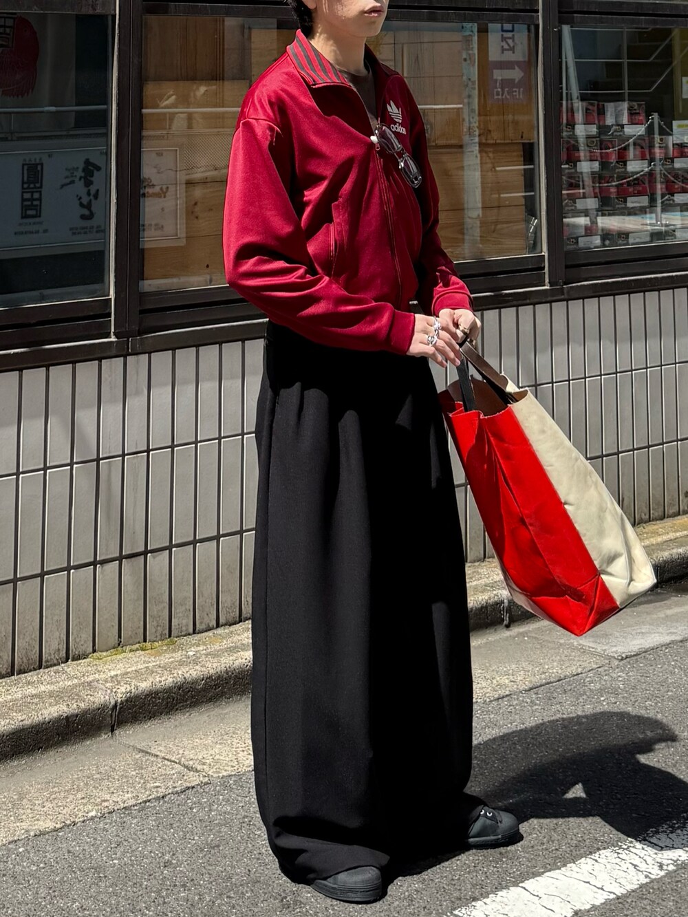 レッド系のその他トップス、ブラウン系のTシャツ/カットソー、ブラック系のスラックスを着用したメンズの春コーディネートの3枚目の写真