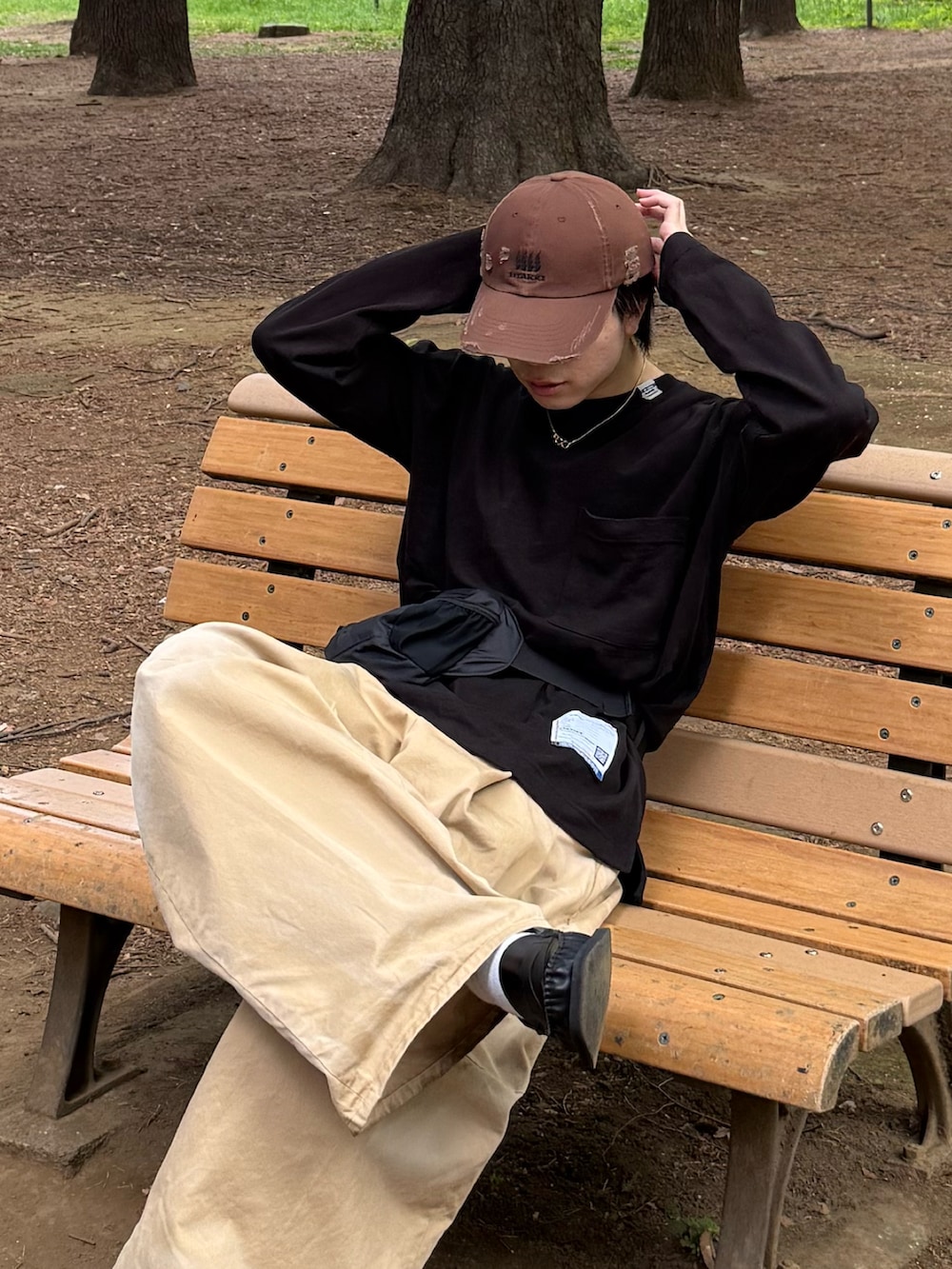 ブラック系のTシャツ/カットソー、ベージュ系のチノパンツ、ブラック系のボディバッグ/ウエストポーチを着用したメンズの春コーディネートの5枚目の写真