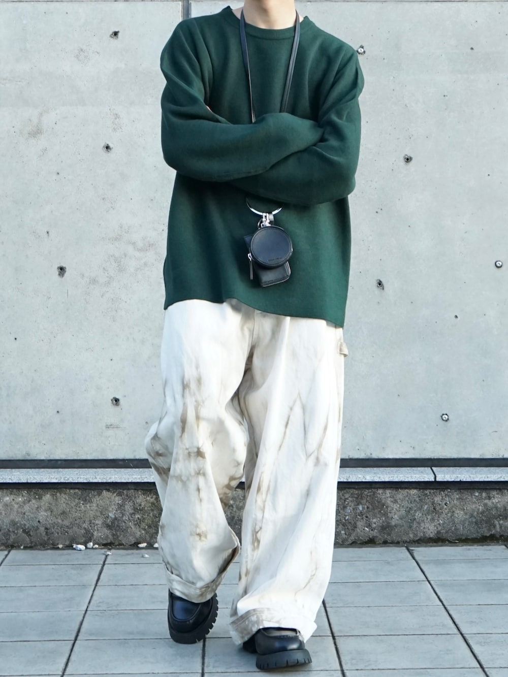 グリーン系のニット/セーター、ベージュ系のその他パンツ、ブラック系のショルダーバッグを着用したメンズの秋コーディネートの5枚目の写真