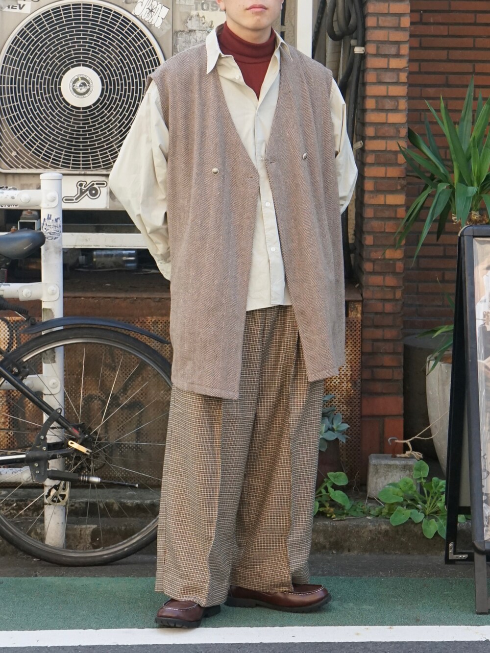 ブラウン系のベスト、ベージュ系のシャツ/ブラウス、レッド系のTシャツ/カットソーを着用したメンズの秋コーディネートの5枚目の写真