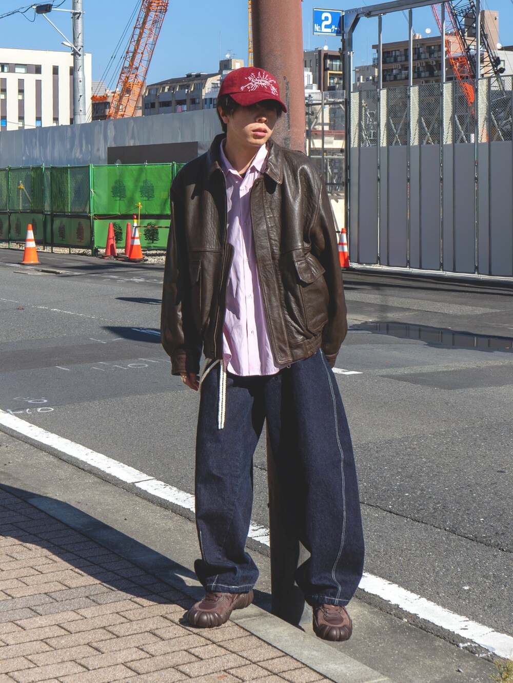 ブラウン系のブルゾン、ピンク系のシャツ/ブラウス、ブルー系のデニムパンツを着用したメンズの秋コーディネートの2枚目の写真