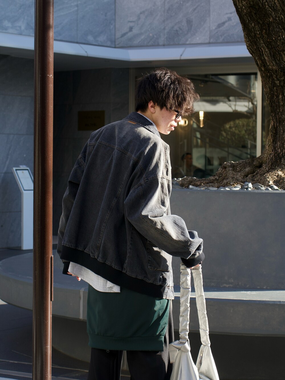 ブラック系のデニムジャケット、ブラック系のシャツ/ブラウス、グリーン系のジャージを着用したメンズの春コーディネートの3枚目の写真