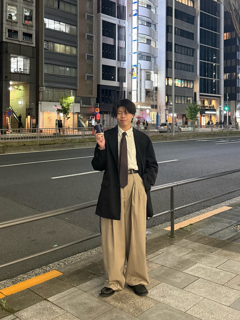 ブラック系のテーラードジャケット、ホワイト系のシャツ/ブラウス、ベージュ系のスラックスを着用したメンズの春コーディネートの3枚目の写真