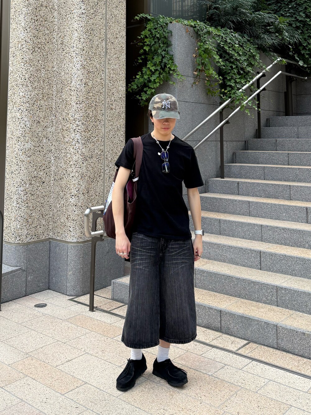 ブラック系のTシャツ/カットソー、グレー系のデニムパンツ、ブラウン系のトートバッグを着用したメンズの夏コーディネートの3枚目の写真