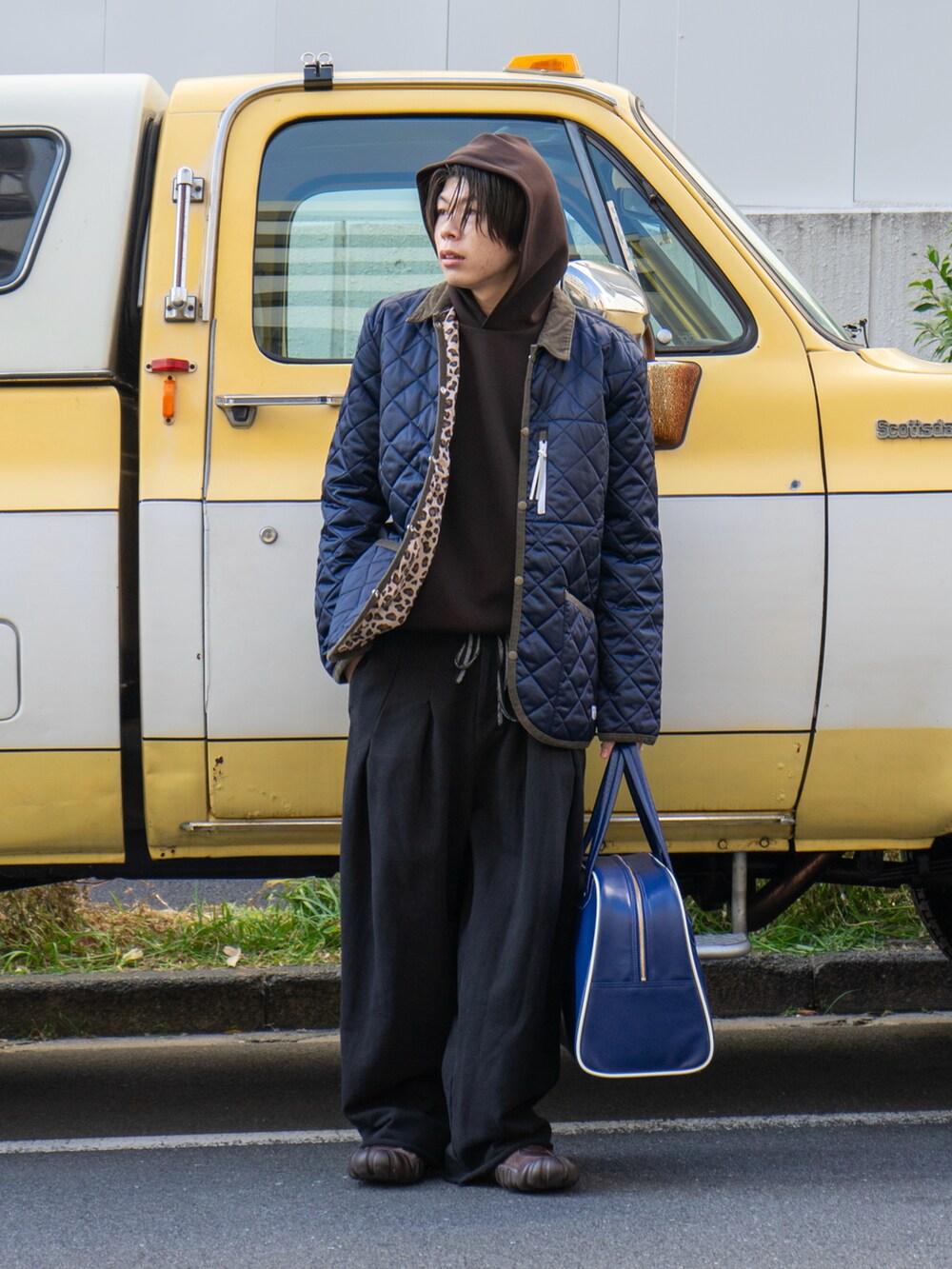 ブラック系のスウェットパンツ、ブルー系のボストンバッグ、ブラウン系のスニーカーを着用したメンズの冬コーディネートの2枚目の写真