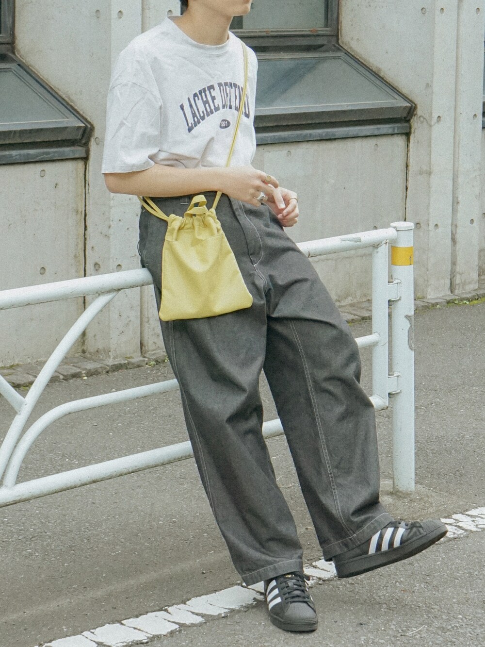 グレー系のTシャツ/カットソー、グレー系のデニムパンツ、イエロー系のショルダーバッグを着用したメンズの夏コーディネートの5枚目の写真