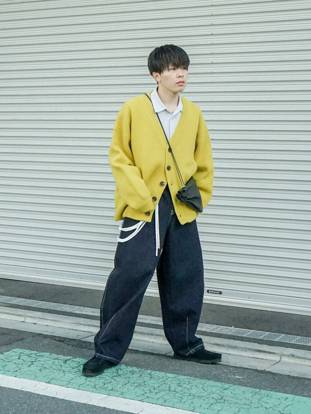 イエロー系のカーディガン/ボレロ、ブラック系のシャツ/ブラウス、ブルー系のデニムパンツを着用したメンズの冬コーディネートの2枚目の写真