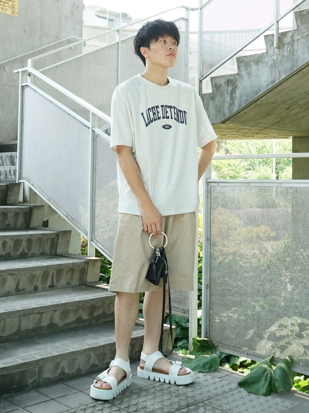 グレー系のTシャツ/カットソー、ベージュ系のその他パンツ、ブラック系のショルダーバッグを着用したメンズの夏コーディネートの4枚目の写真