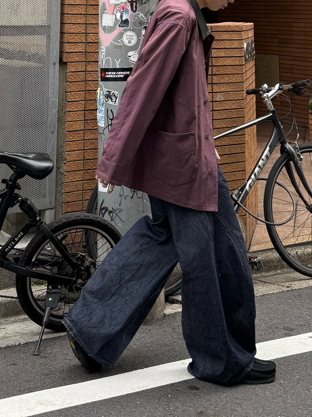 グレー系のTシャツ/カットソー、ブルー系のデニムパンツ、ブラック系のモカシン/デッキシューズを着用したメンズの秋コーディネートの3枚目の写真