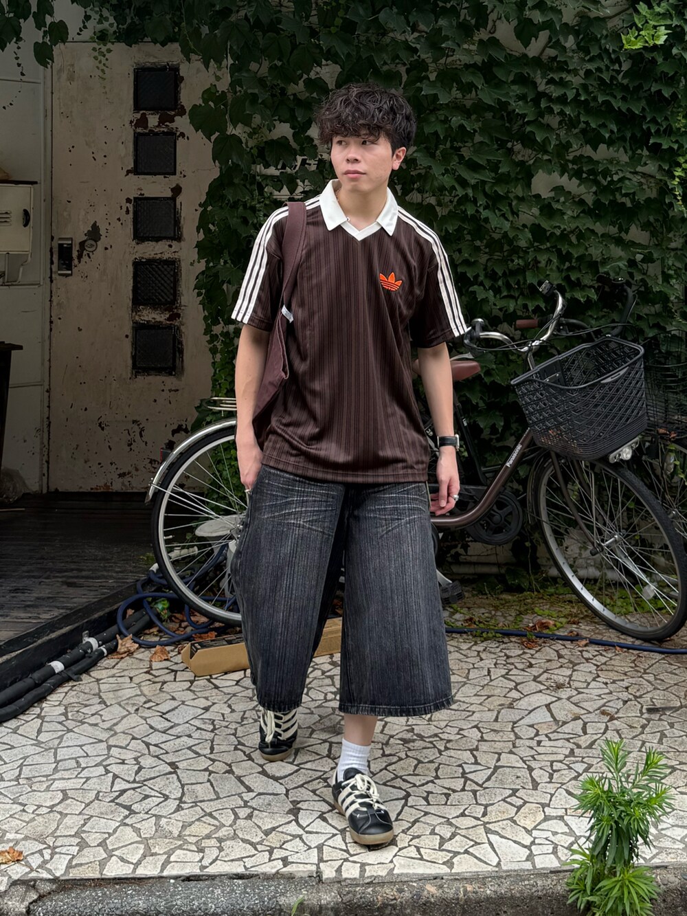 ブラウン系のTシャツ/カットソー、グレー系のデニムパンツ、ブラウン系のトートバッグを着用したメンズの夏コーディネートの2枚目の写真