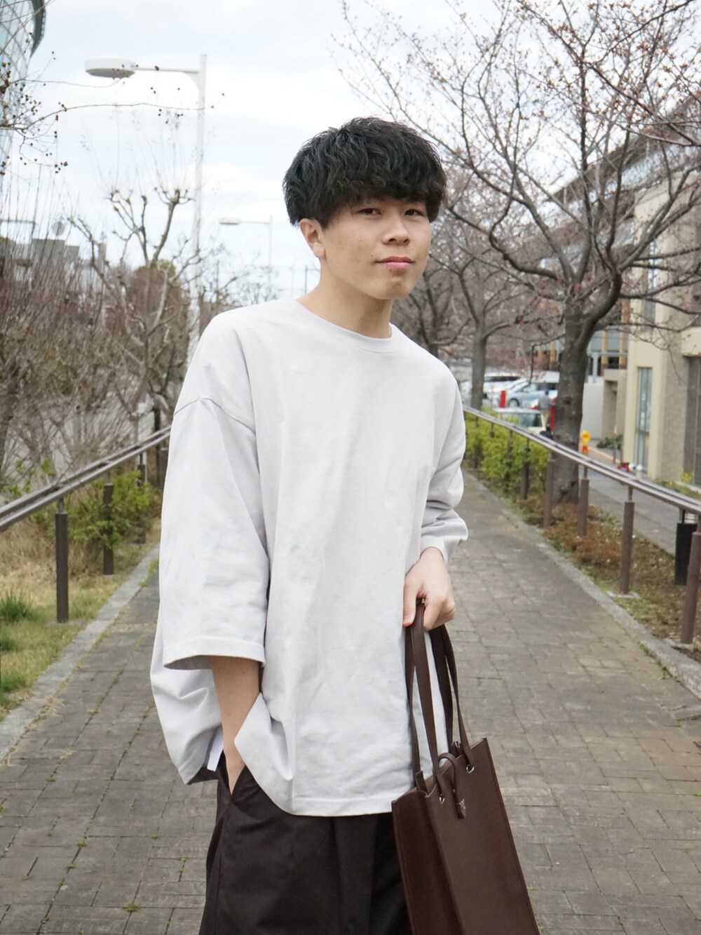 グレー系のTシャツ/カットソー、ブラウン系のカーゴパンツ、ブラウン系のトートバッグを着用したメンズの春コーディネートの4枚目の写真