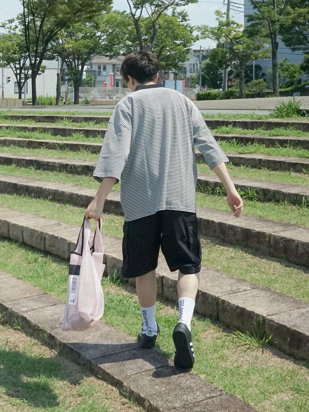 ピンク系のトートバッグ、ブラック系のスニーカー、ブルー系のその他を着用したメンズの夏コーディネートの2枚目の写真