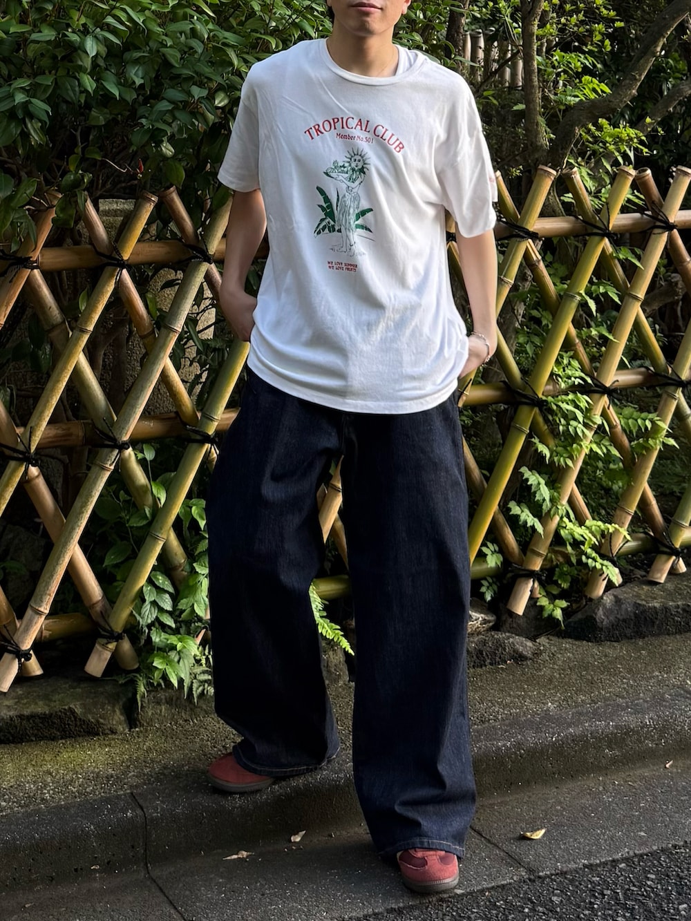 ブルー系のデニムパンツ、ブラウン系のスニーカー、ホワイト系のTシャツ/カットソーを着用したメンズの夏コーディネートの2枚目の写真