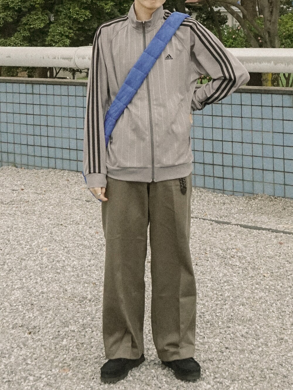 ブラウン系のその他パンツ、ブルー系のショルダーバッグ、ブラック系のその他シューズを着用したメンズの春コーディネートの3枚目の写真