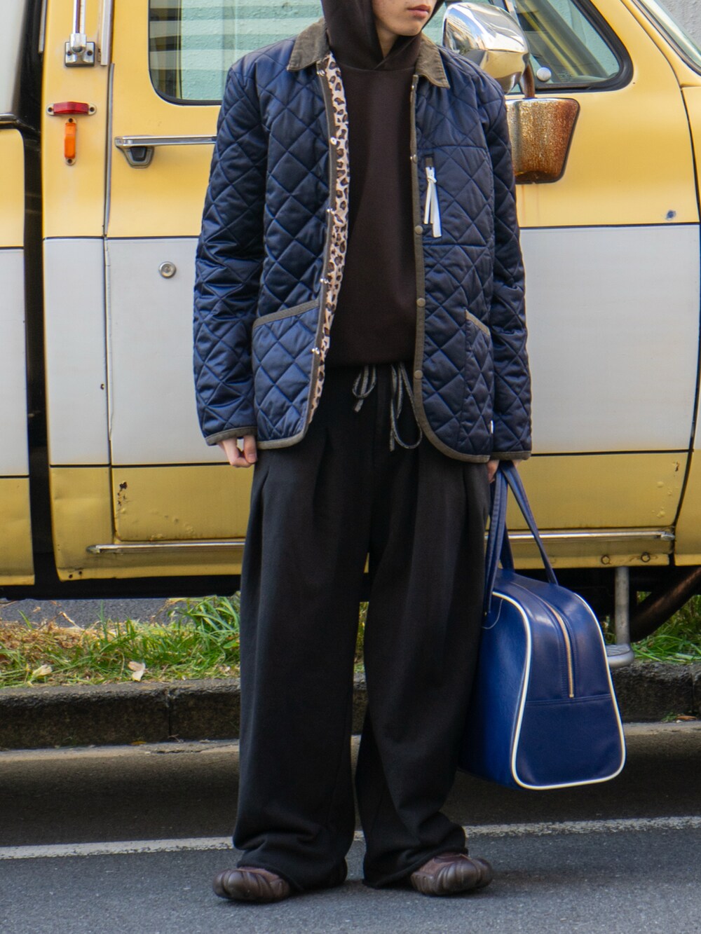 ブラック系のスウェットパンツ、ブルー系のボストンバッグ、ブラウン系のスニーカーを着用したメンズの冬コーディネートの5枚目の写真