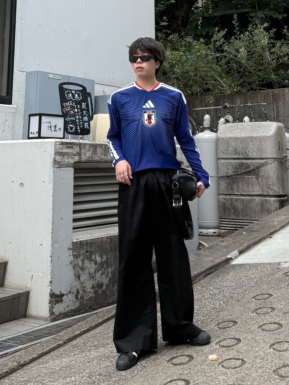 ブルー系のTシャツ/カットソー、ブラック系のその他パンツ、ブラック系のショルダーバッグを着用したメンズの夏コーディネートの3枚目の写真
