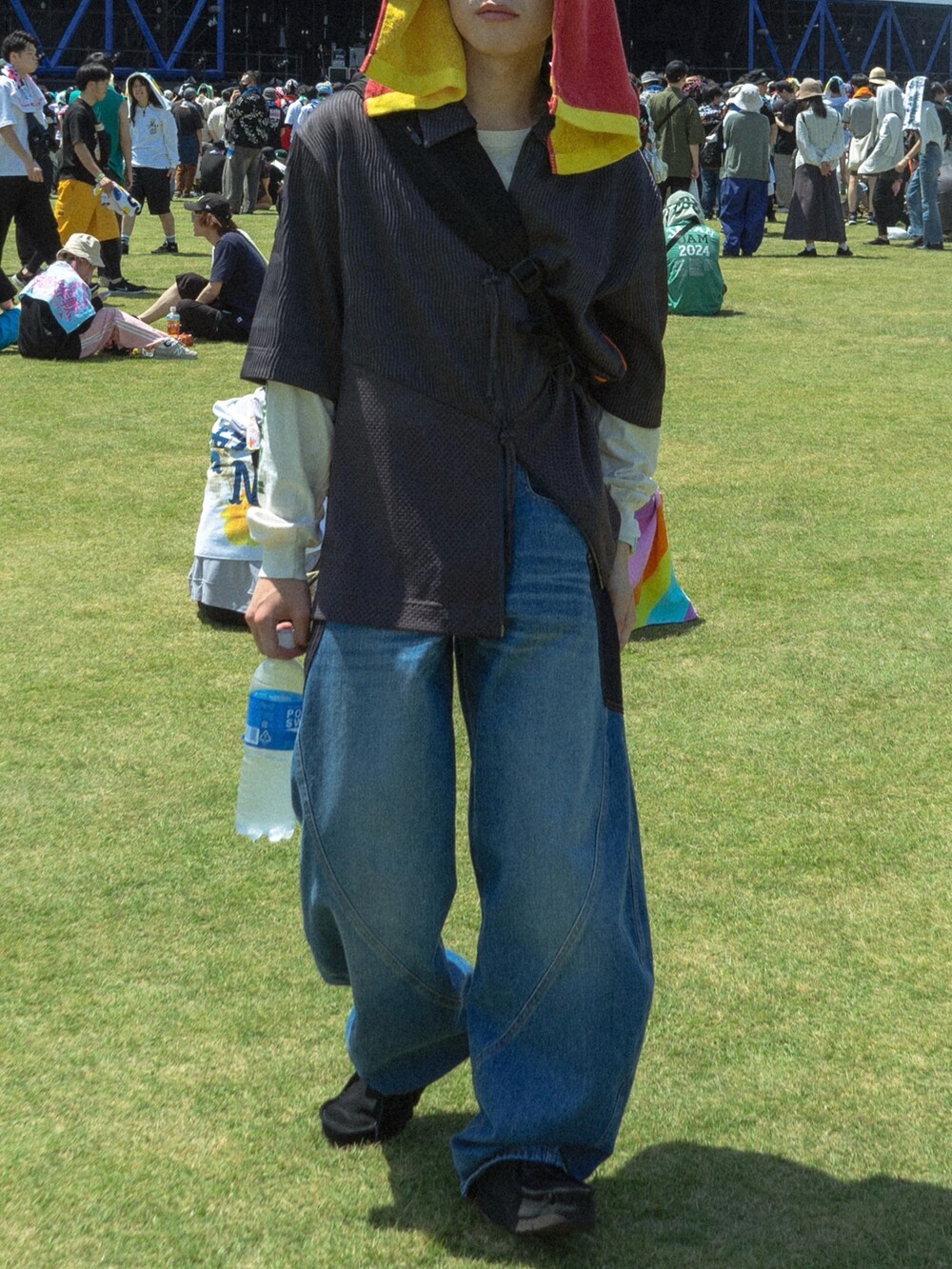 グレー系のトップス、ブラック系のショルダーバッグ、ブルー系のデニムパンツを着用したメンズの春コーディネートの5枚目の写真