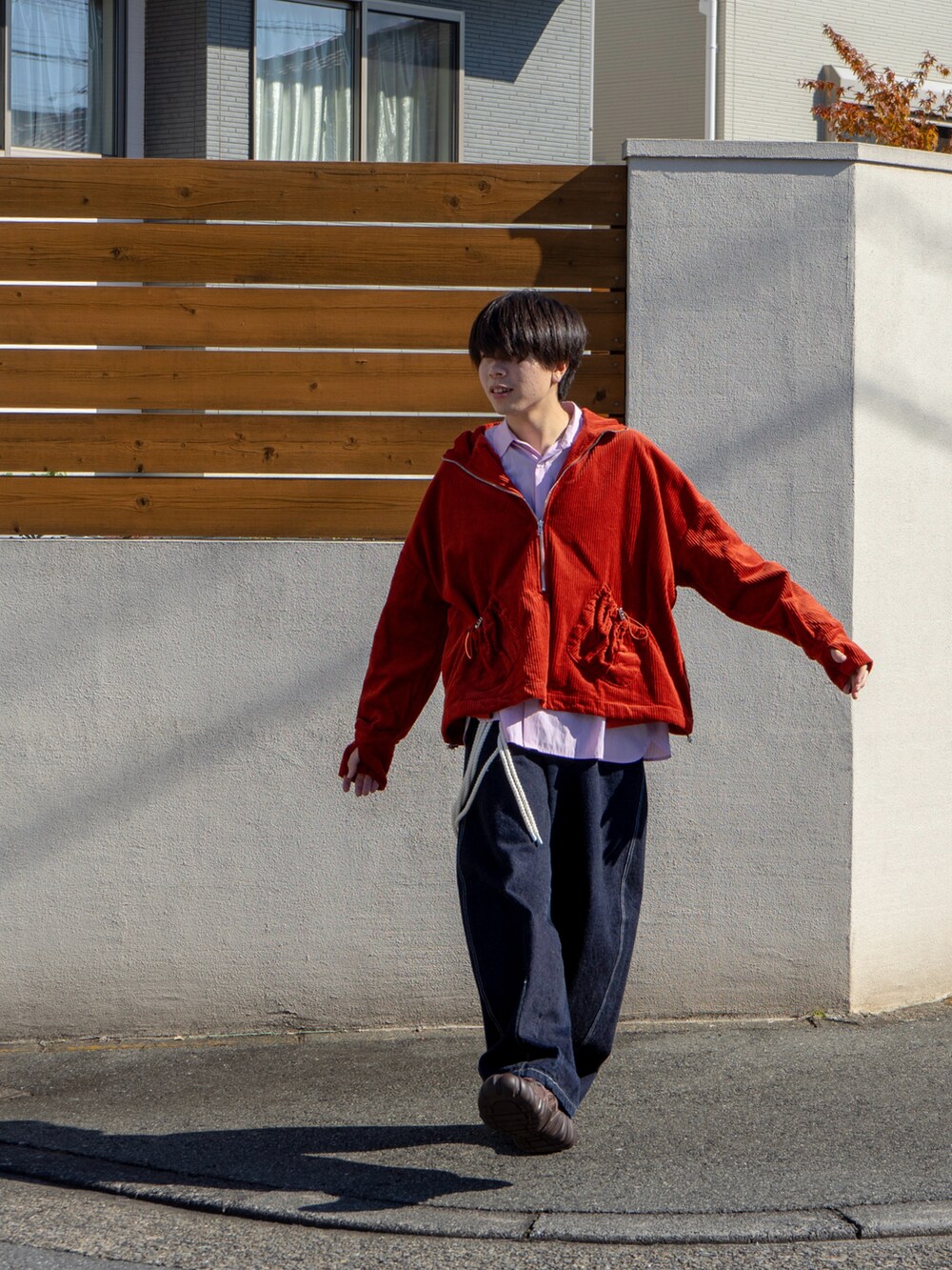 オレンジ系のブルゾン、ピンク系のシャツ/ブラウス、ブルー系のデニムパンツを着用したメンズの秋コーディネートの3枚目の写真