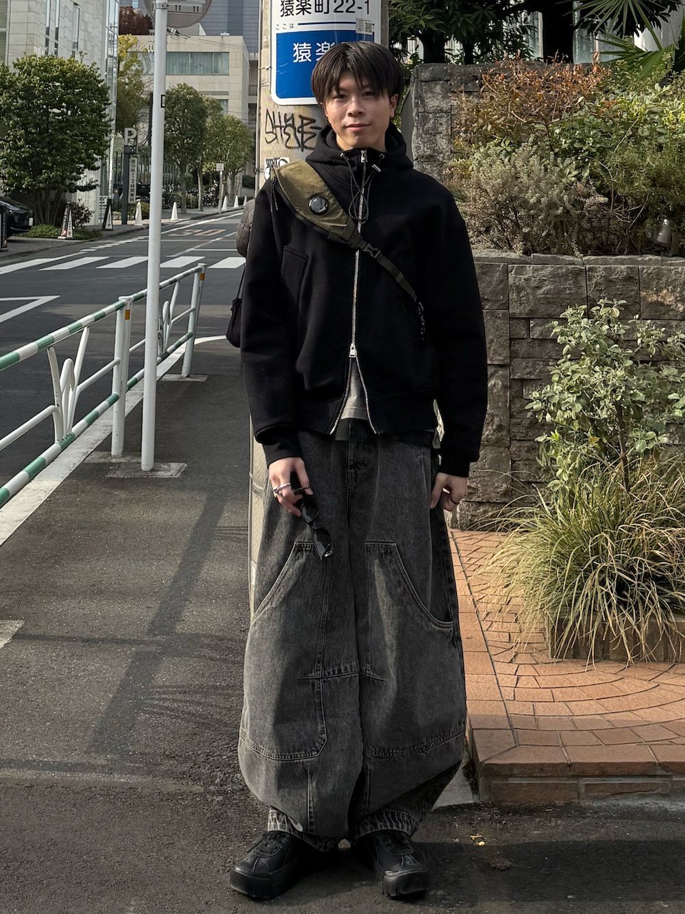 ブラック系のパーカー、ホワイト系のTシャツ/カットソー、グリーン系のバックパック/リュックを着用したメンズの春コーディネートの2枚目の写真