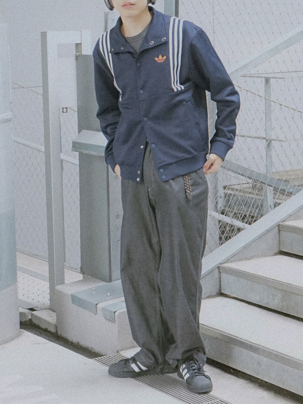 ブルー系のジャージ、グレー系のデニムパンツ、ブラック系のスニーカーを着用したメンズの春コーディネートの5枚目の写真