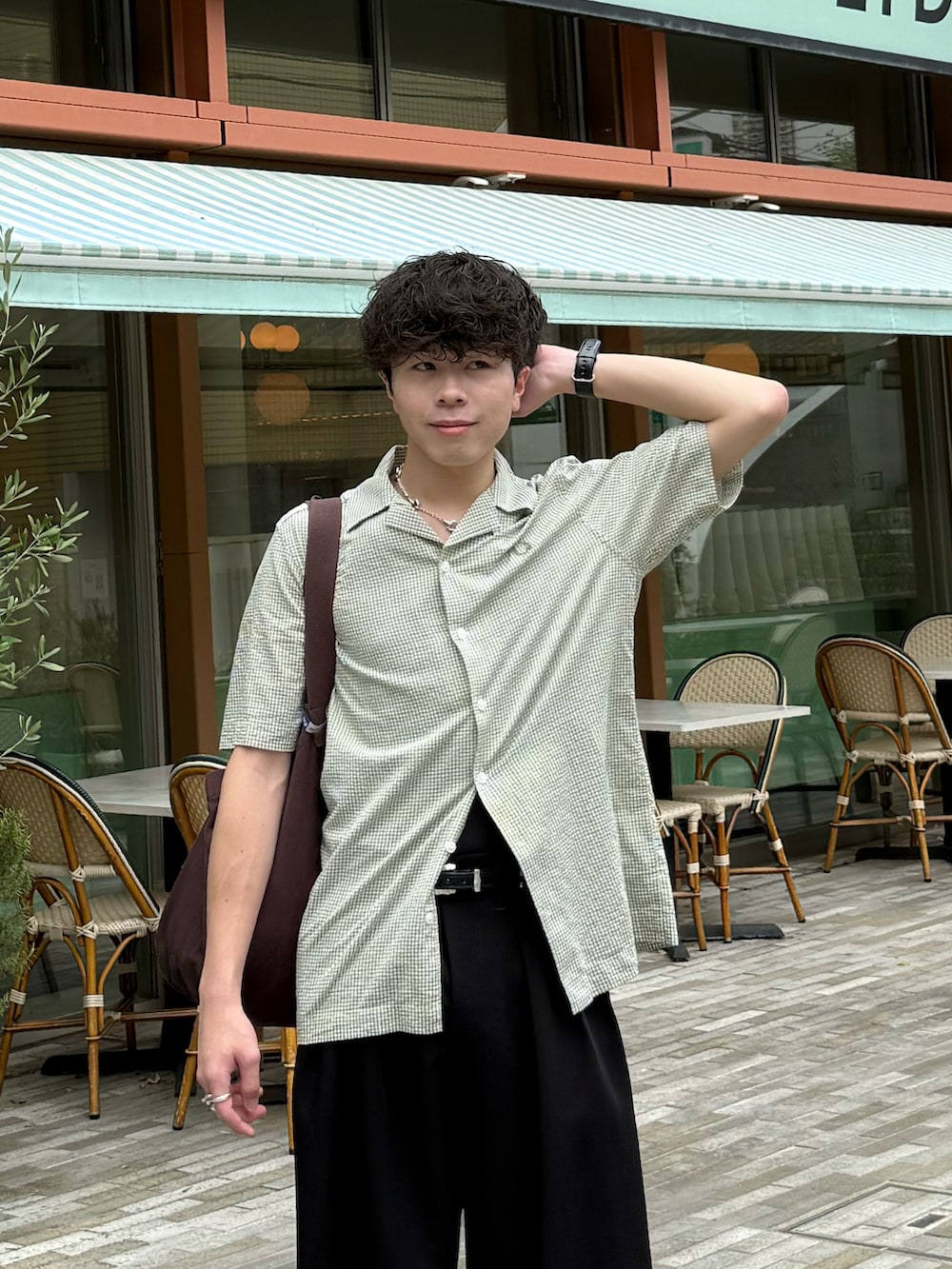 グリーン系のシャツ/ブラウス、ブラック系のスラックス、ブラウン系のトートバッグを着用したメンズの夏コーディネートの4枚目の写真