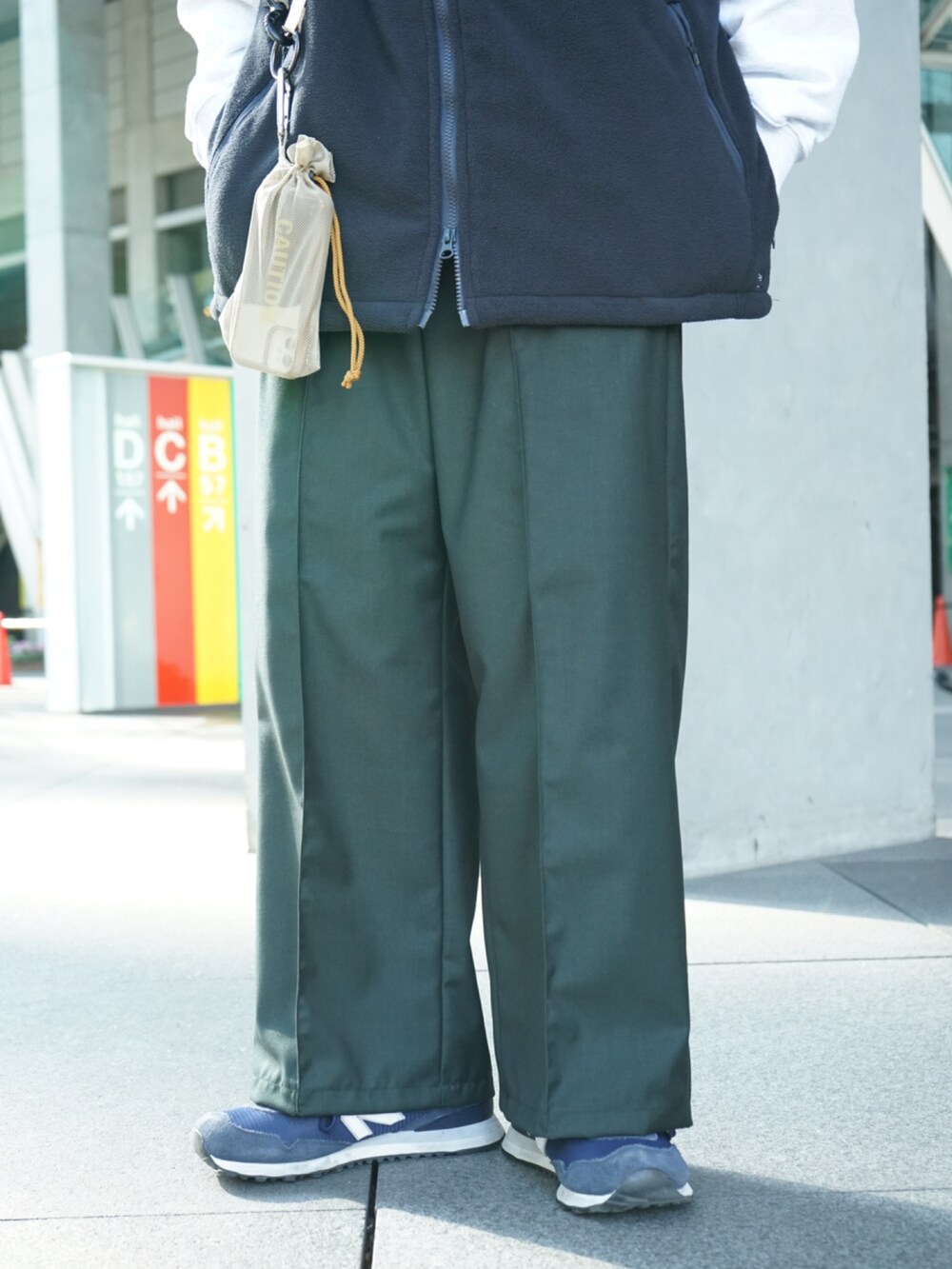 ブルー系のその他アウター、ベージュ系のショルダーバッグ、グリーン系のその他パンツを着用したメンズの冬コーディネートの4枚目の写真