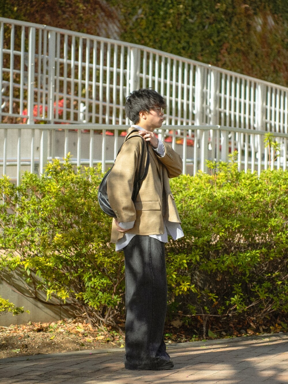 ブラウン系のテーラードジャケット、ブラック系のシャツ/ブラウス、ブラック系のデニムパンツを着用したメンズの春コーディネートの3枚目の写真