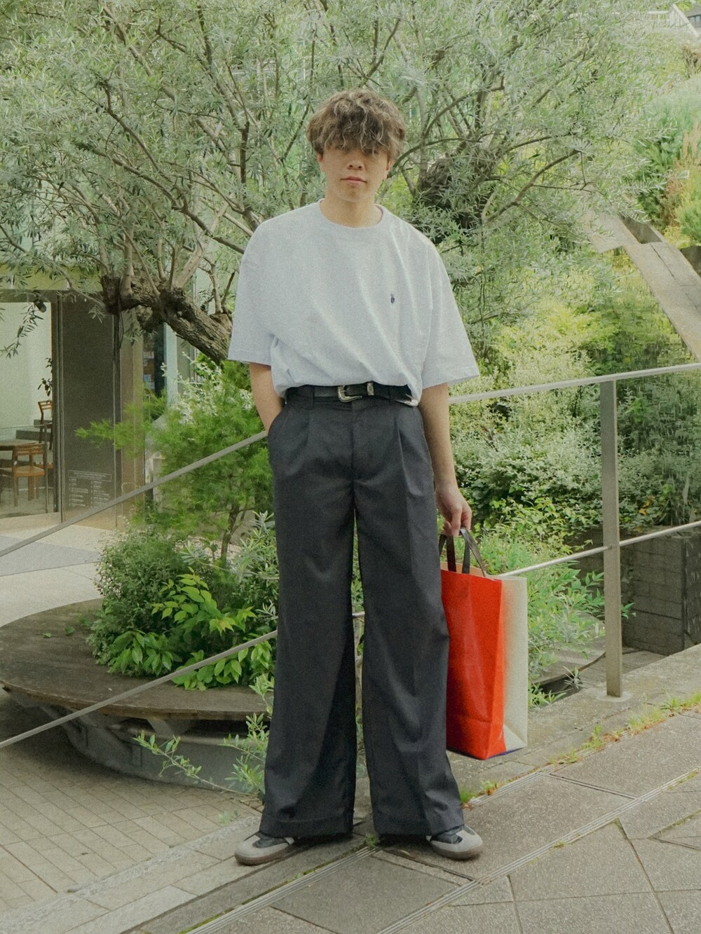 グレー系のTシャツ/カットソー、グレー系のスラックス、ホワイト系のトートバッグを着用したメンズの春コーディネートの2枚目の写真