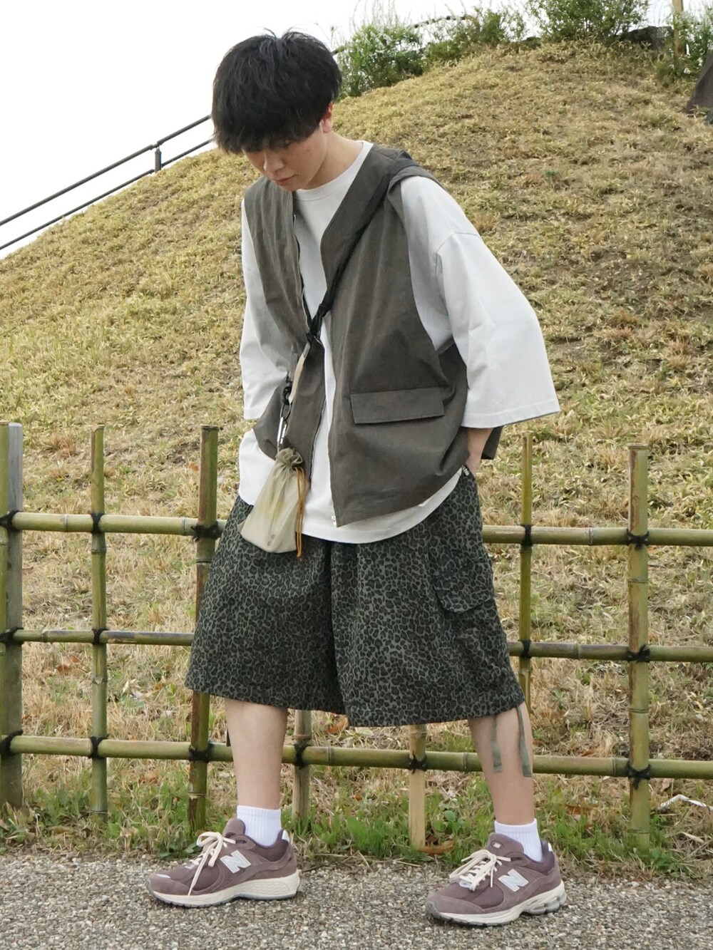 グレー系のベスト、グレー系のTシャツ/カットソー、グリーン系のその他パンツを着用したメンズの春コーディネートの4枚目の写真