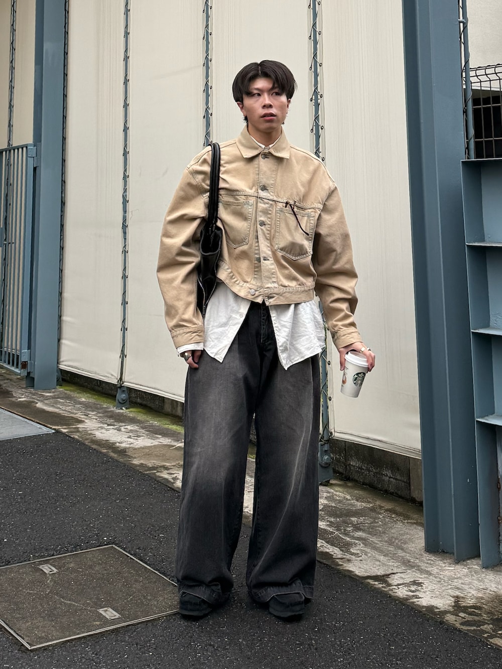 ベージュ系のデニムジャケット、ブラック系のデニムパンツ、ブラック系のモカシン/デッキシューズを着用したメンズの秋コーディネートの2枚目の写真