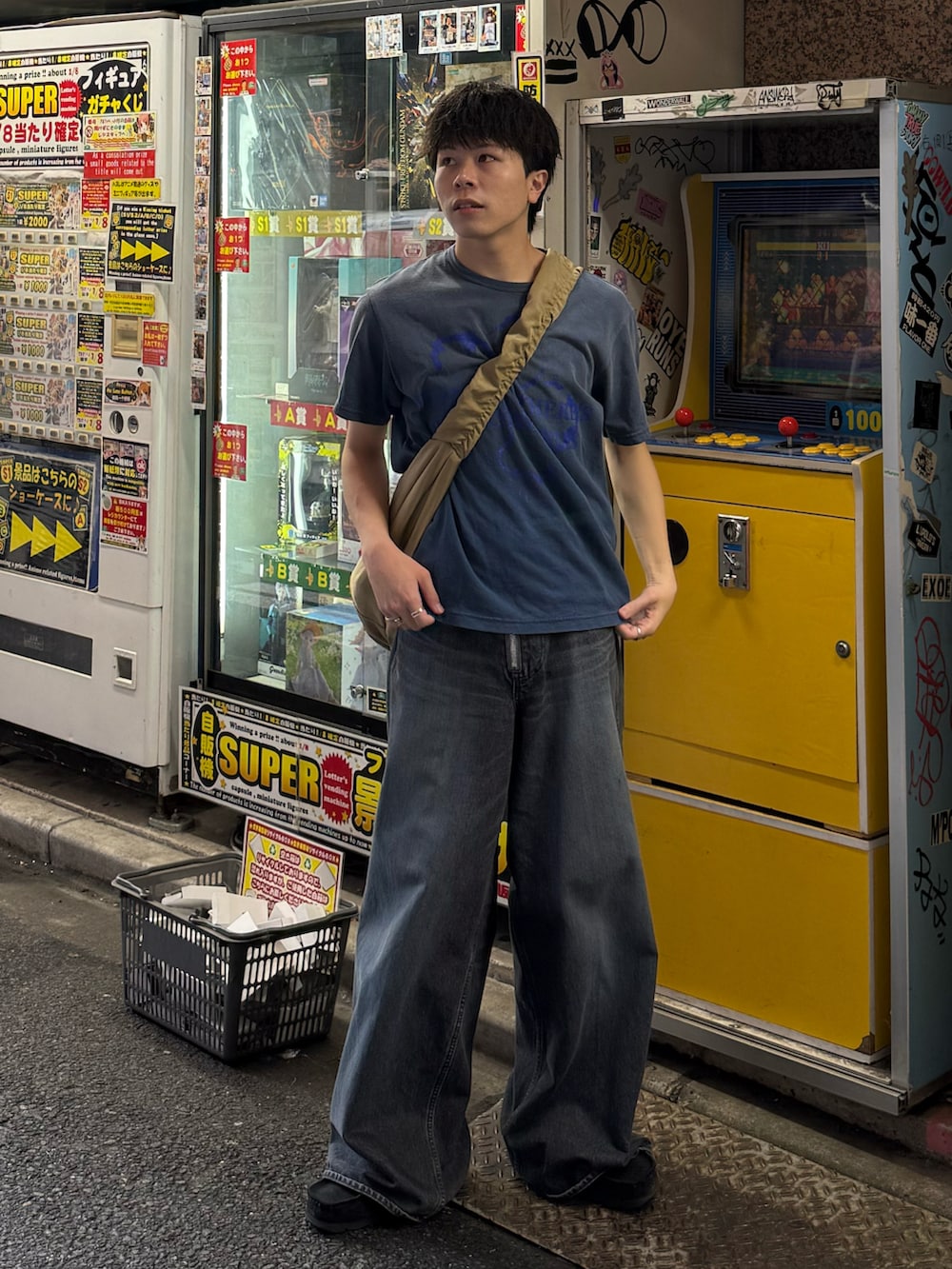 ブルー系のTシャツ/カットソー、ブルー系のデニムパンツ、ベージュ系のショルダーバッグを着用したメンズの夏コーディネートの2枚目の写真