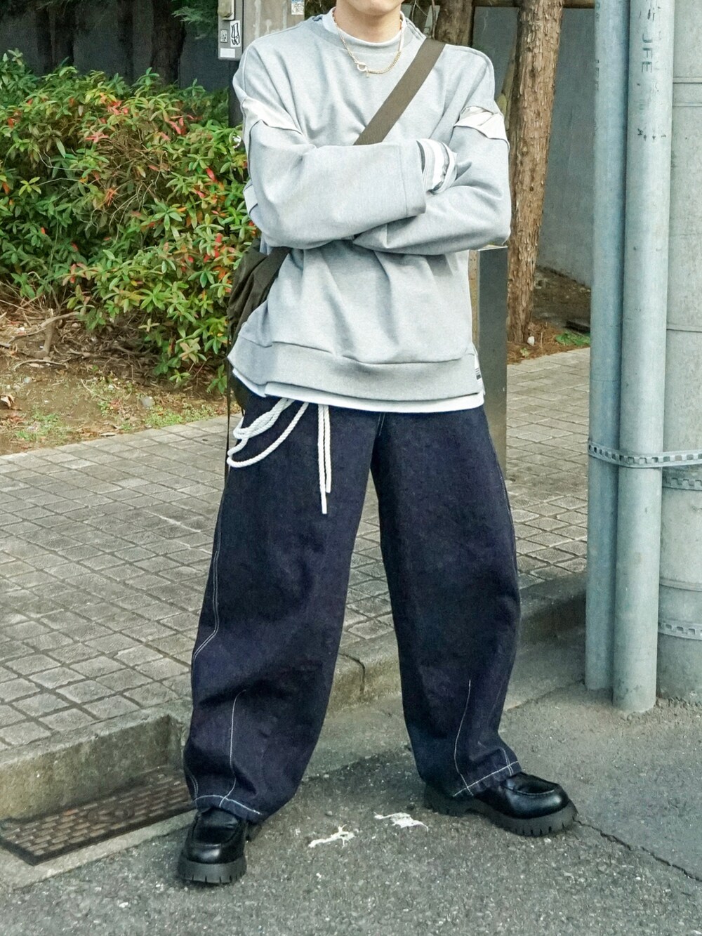 グレー系のスウェット、グレー系のTシャツ/カットソー、ブルー系のデニムパンツを着用したメンズの冬コーディネートの5枚目の写真