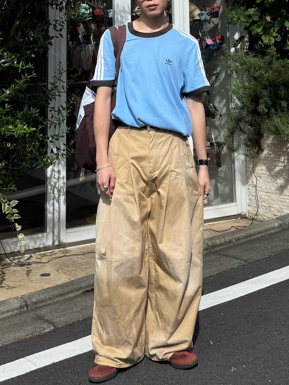 ベージュ系のチノパンツ、ブラウン系のトートバッグ、ブラウン系のスニーカーを着用したメンズの夏コーディネートの2枚目の写真