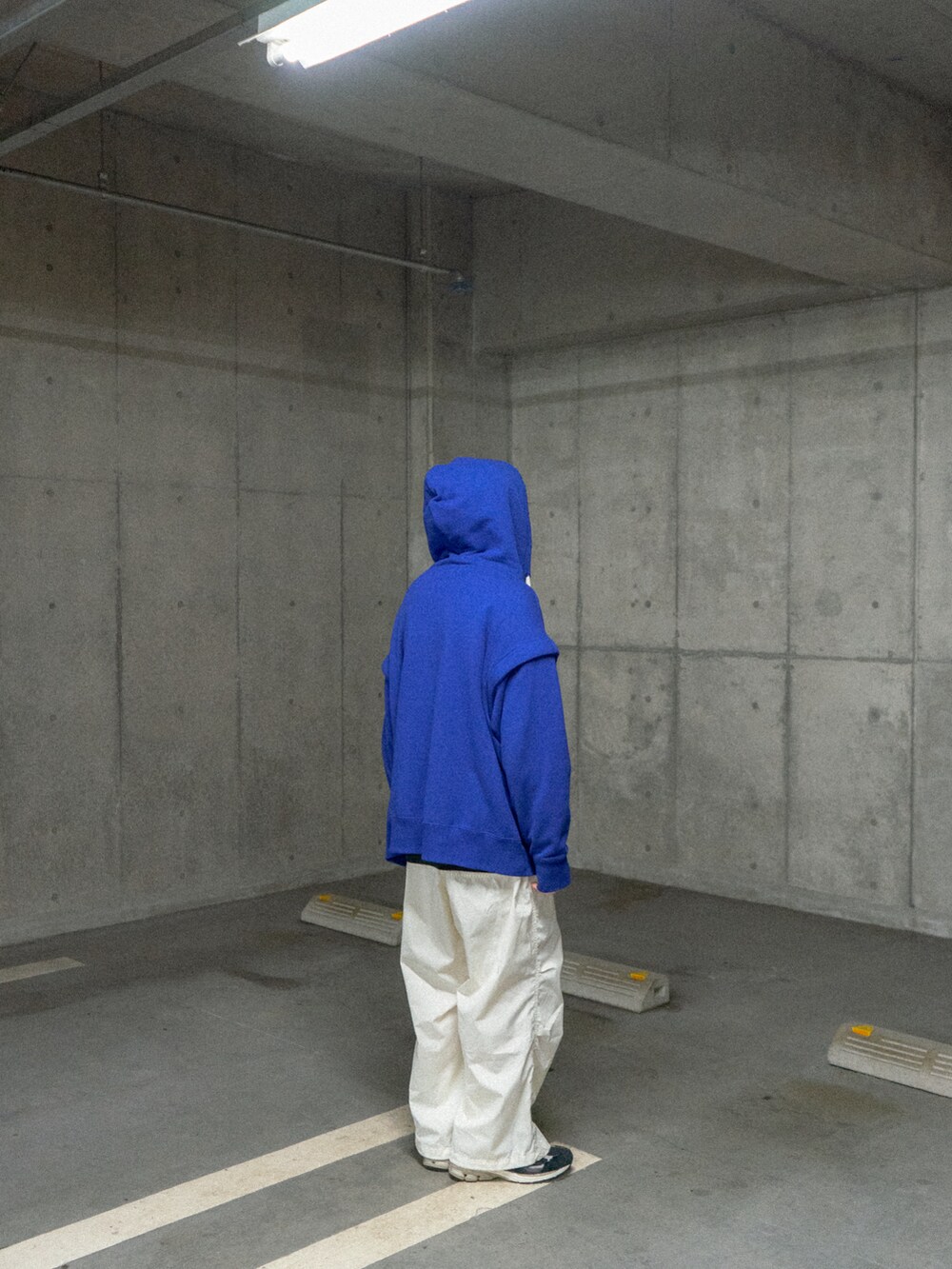 ブルー系のパーカー、ホワイト系のカーゴパンツ、ブラック系のスニーカーを着用したメンズの冬コーディネートの3枚目の写真