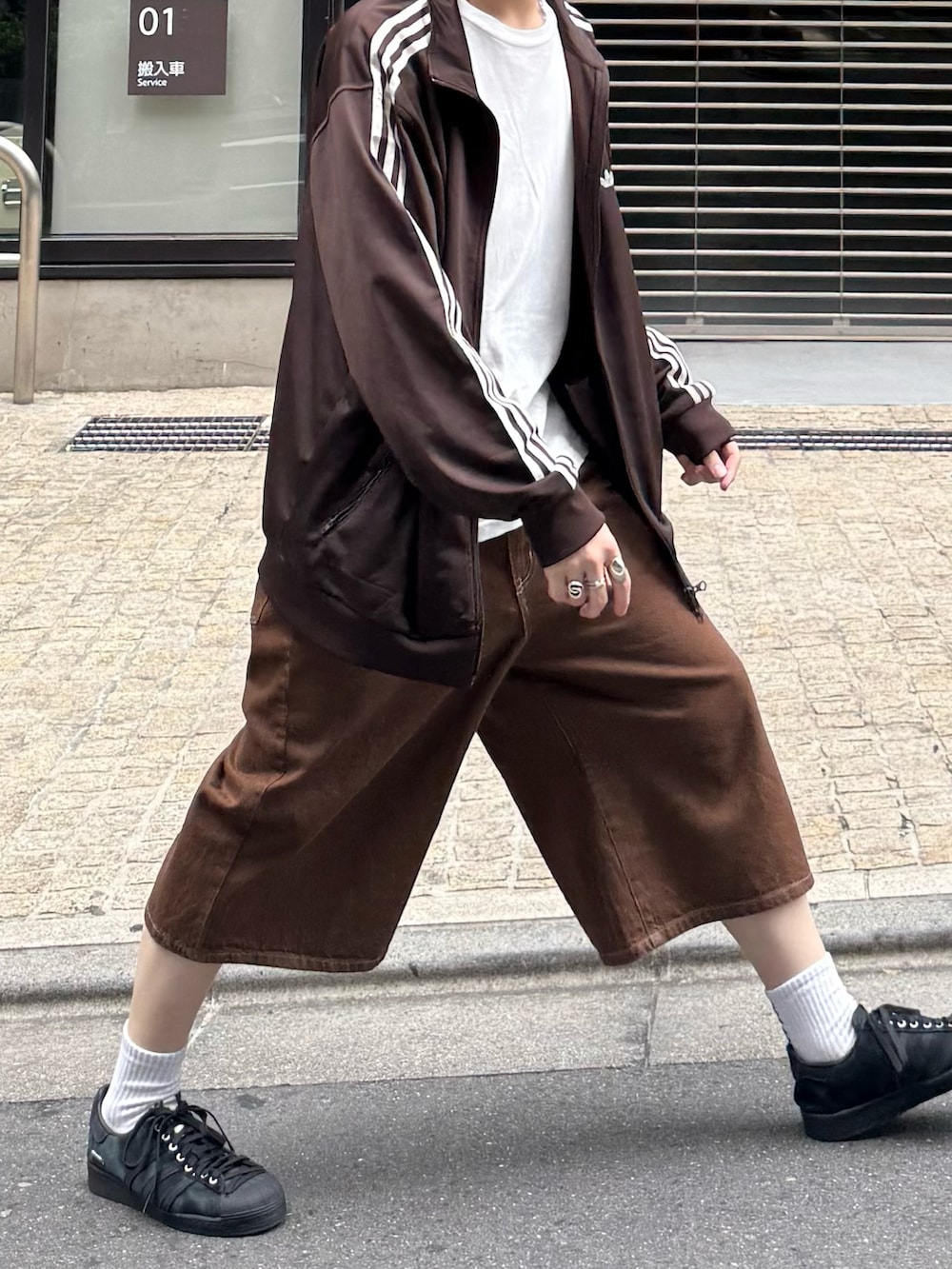 ブラウン系のジャージ、ホワイト系のTシャツ/カットソー、ブラウン系のデニムパンツを着用したメンズの春コーディネートの4枚目の写真