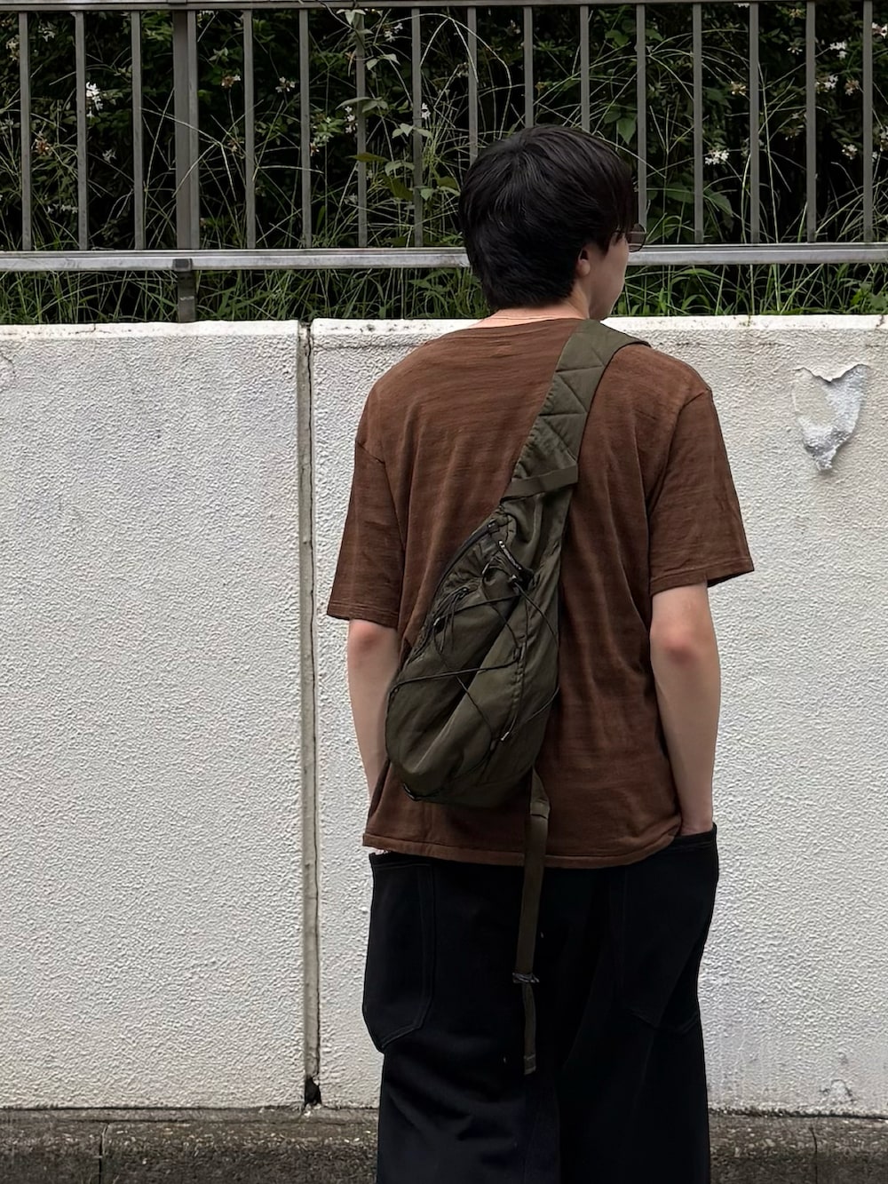 ブラウン系のTシャツ/カットソー、ブラック系のスウェットパンツ、グリーン系のバックパック/リュックを着用したメンズの夏コーディネートの2枚目の写真