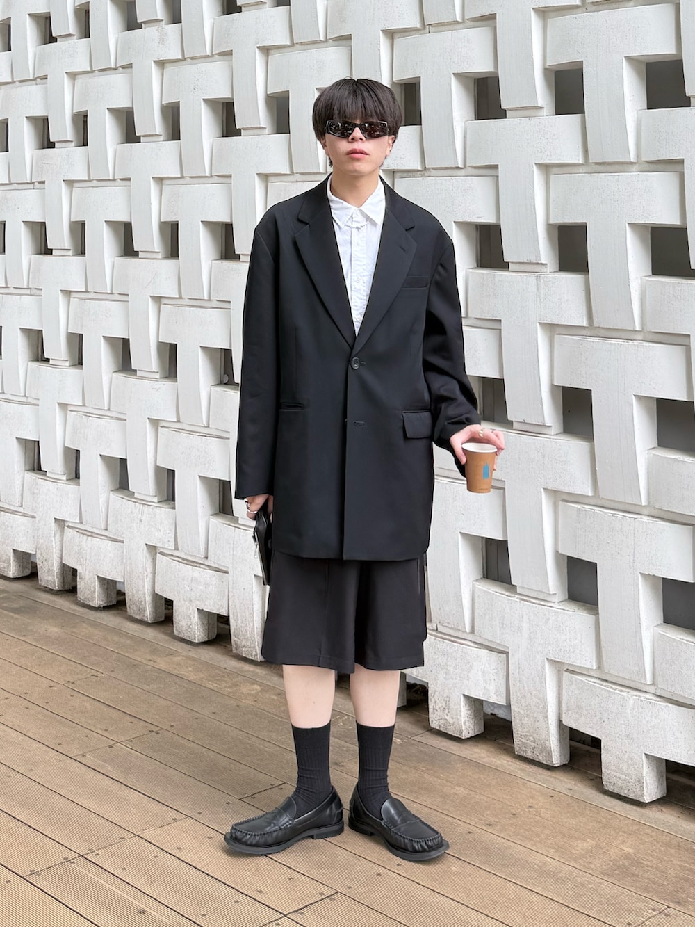 ブラック系のテーラードジャケット、ホワイト系のシャツ/ブラウス、ブラック系のその他パンツを着用したメンズの春コーディネートの2枚目の写真