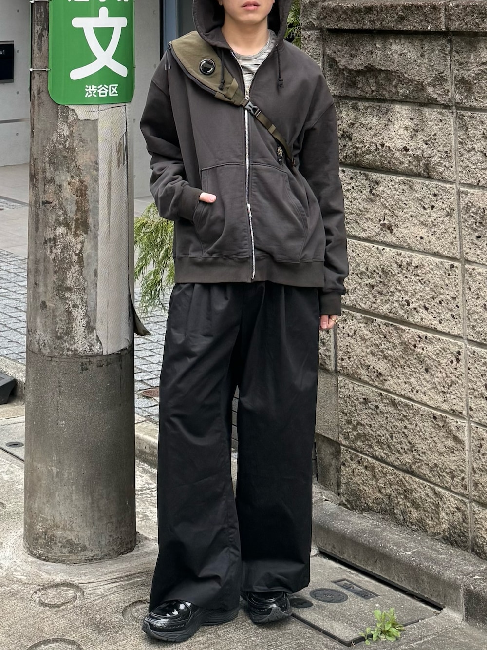 ブラック系のパーカー、グレー系のTシャツ/カットソー、グリーン系のバックパック/リュックを着用したメンズの春コーディネートの5枚目の写真