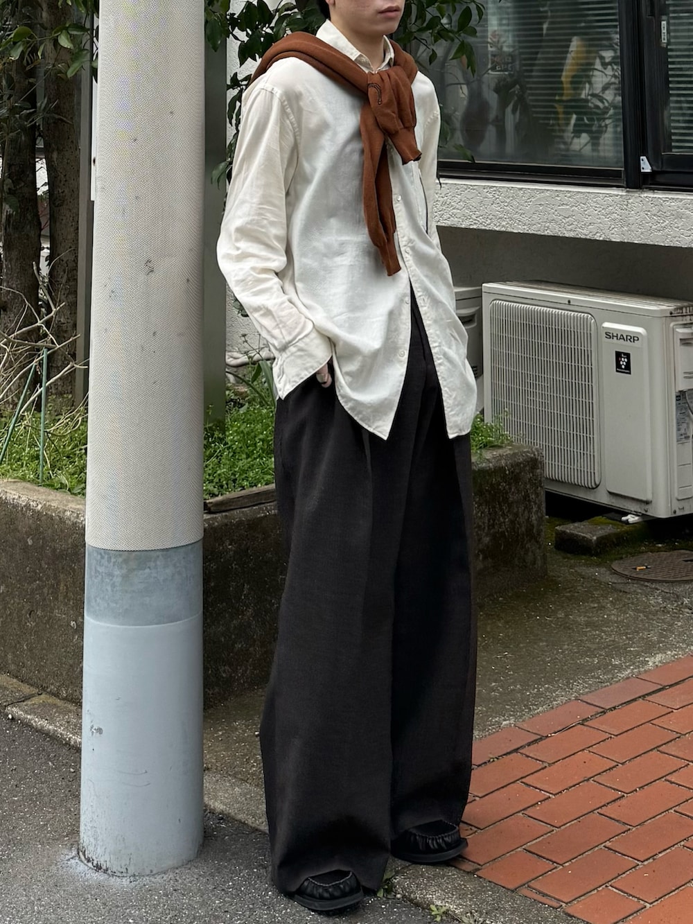 ブラウン系のカーディガン/ボレロ、ブラウン系のスラックス、ブラック系のローファーを着用したメンズの春コーディネートの4枚目の写真