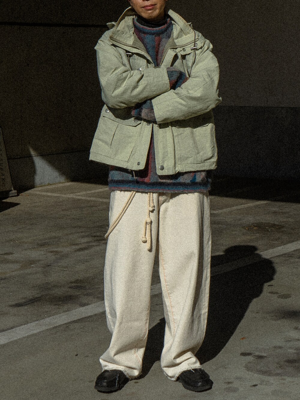 ベージュ系のマウンテンパーカー、ブラック系のデニムパンツ、ブラック系のブーツを着用したメンズの冬コーディネートの5枚目の写真