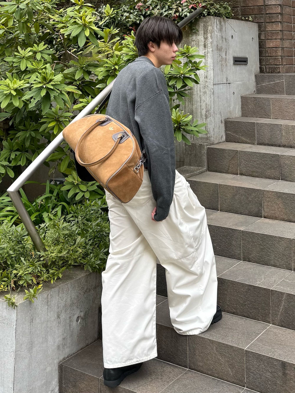 グレー系のニット/セーター、グレー系のTシャツ/カットソー、ホワイト系のその他パンツを着用したメンズの春コーディネートの2枚目の写真