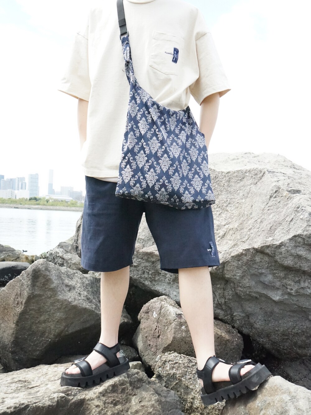 ベージュ系のTシャツ/カットソー、ブルー系のスウェットパンツ、ブルー系のショルダーバッグを着用したメンズの春コーディネートの3枚目の写真