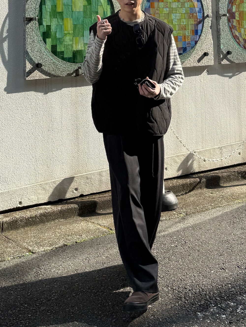 ブラック系のその他アウター、グレー系のTシャツ/カットソー、グレー系のスラックスを着用したメンズの春コーディネートの3枚目の写真