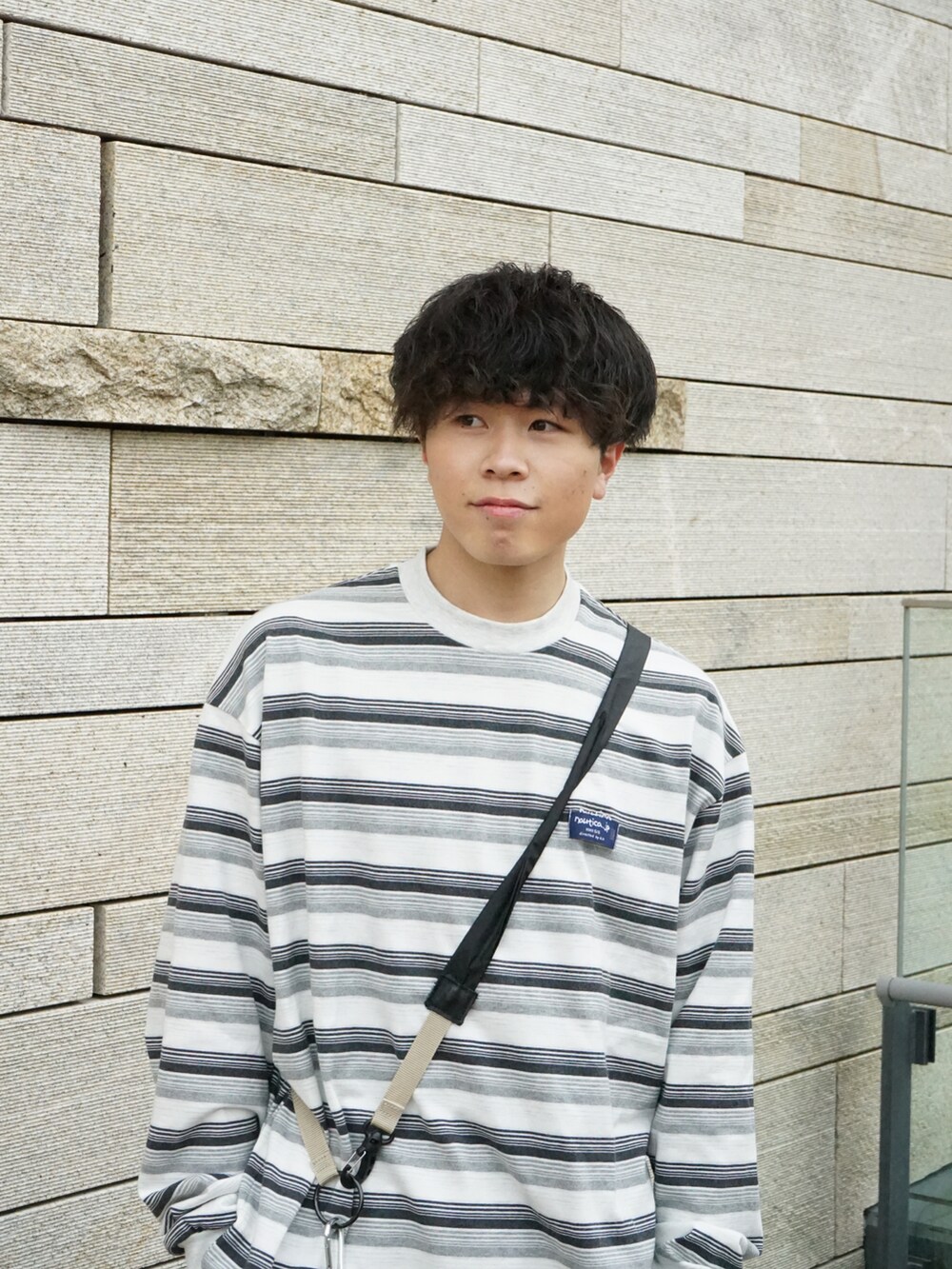 グレー系のTシャツ/カットソー、グレー系のスウェットパンツ、ベージュ系のショルダーバッグを着用したメンズの春コーディネートの4枚目の写真