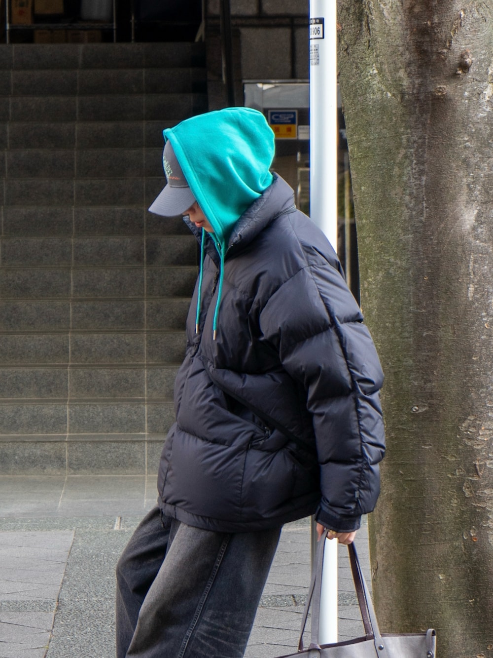 ブラック系のダウンジャケット/コート、ブルー系のパーカー、ブラック系のその他シューズを着用したメンズの冬コーディネートの4枚目の写真