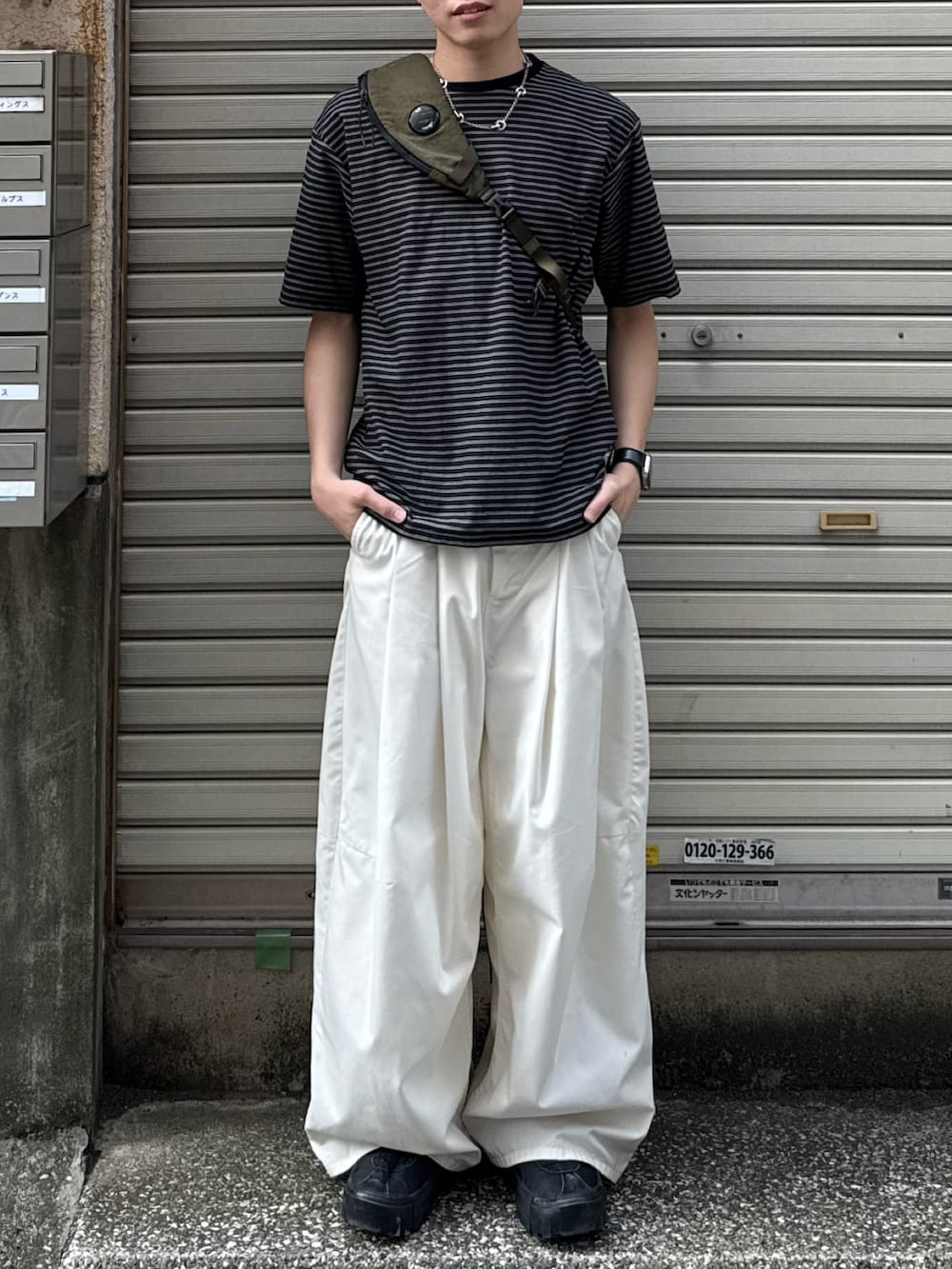 ブラック系のTシャツ/カットソー、ホワイト系のその他パンツ、ブラック系のスニーカーを着用したメンズの夏コーディネートの4枚目の写真